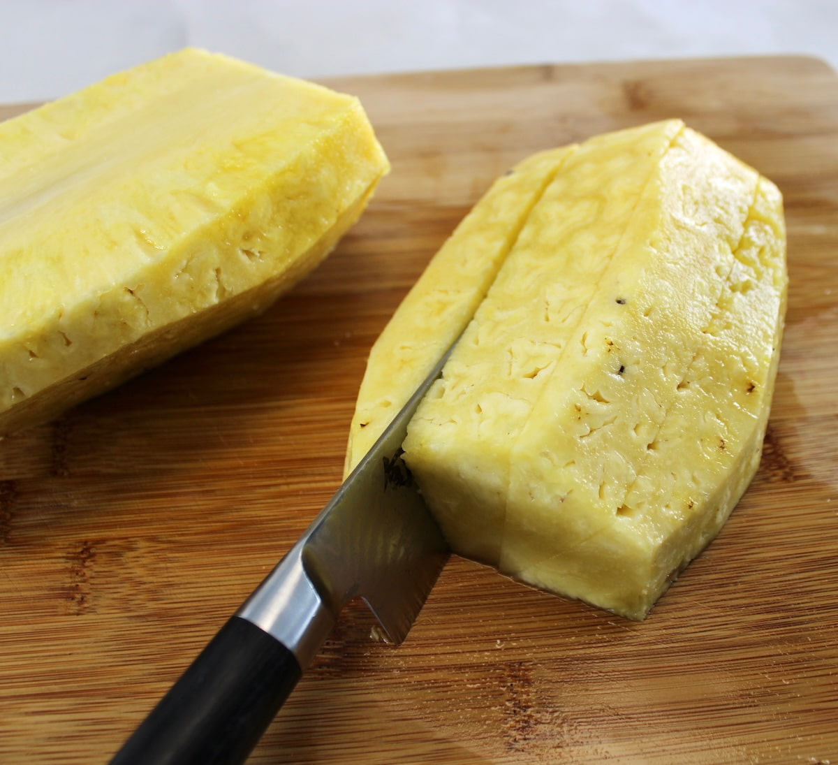 cutting fresh pineapple on cutting board