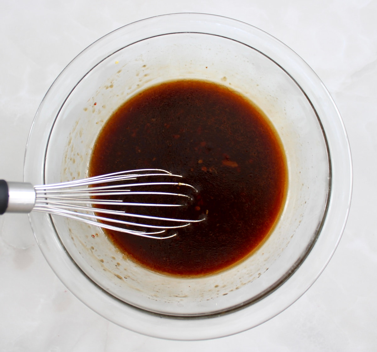 Grilled Asian Chicken marinade in glass bowl with whisk
