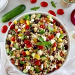 overhead view of Mediterranean Farro Salad in white bowl with fresh veggies around