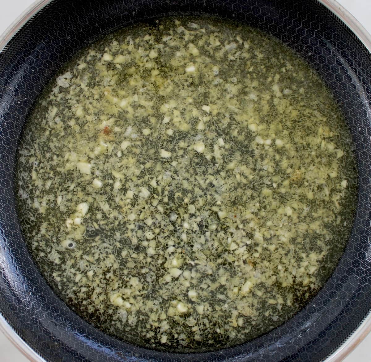 minced garlic and white wine in skillet