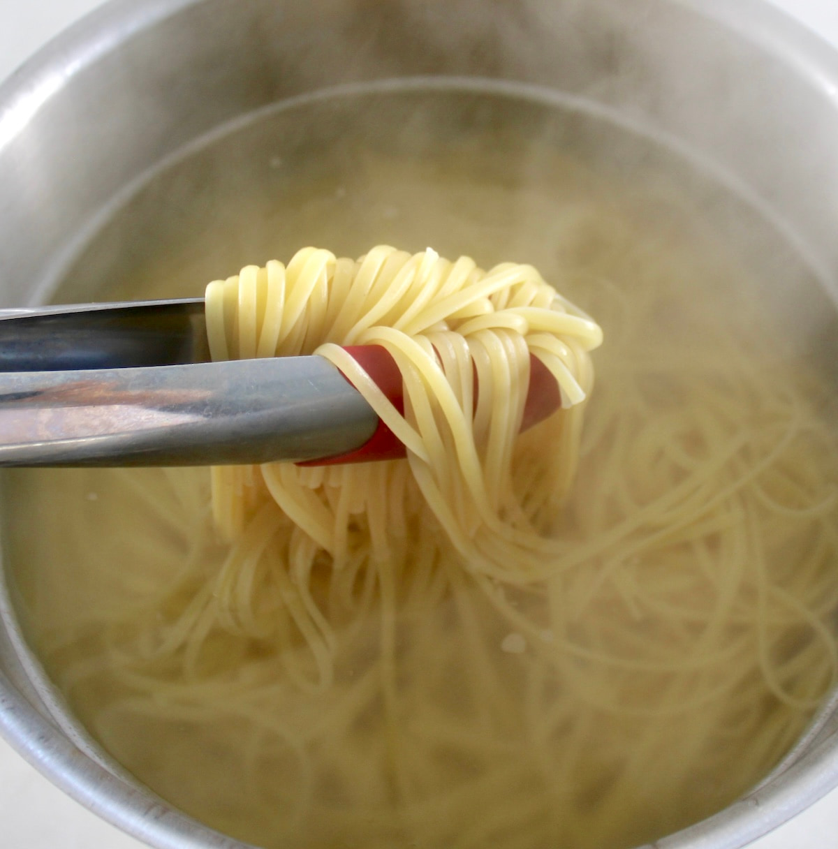 linguine being lifted out of a pot of water