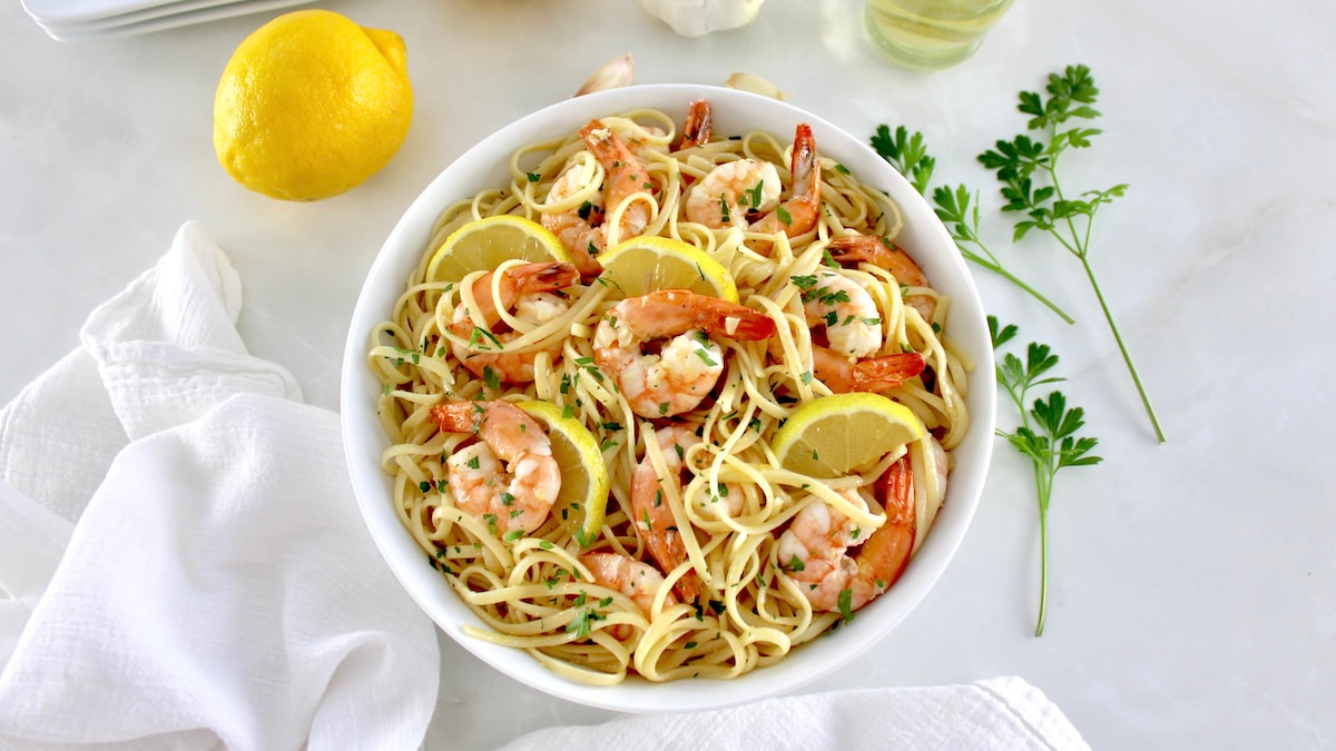 Shrimp Scampi with Linguine in white bowl with lemon slices and parsley