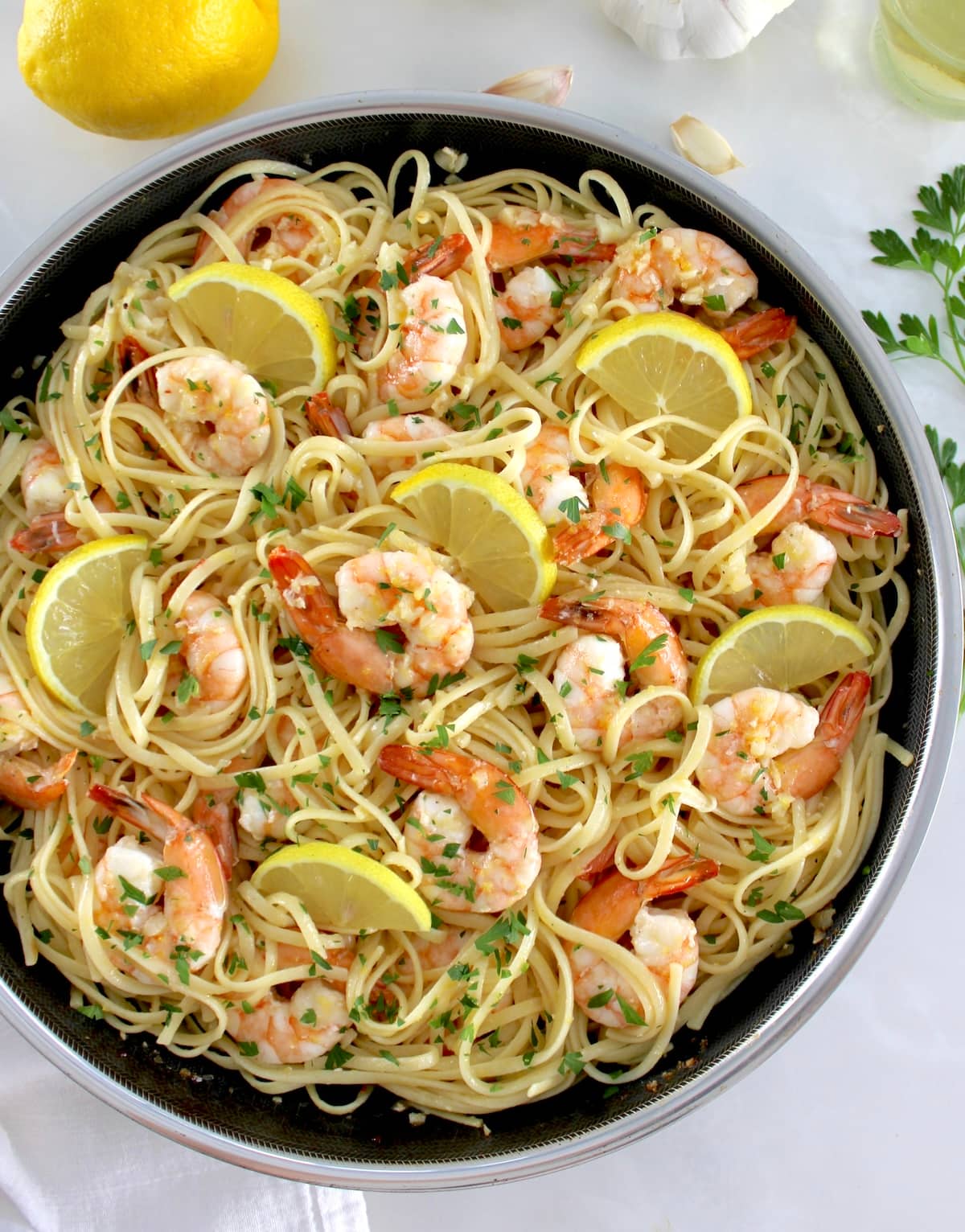 overhead view of Shrimp Scampi with Linguine in skillet with lemon slices