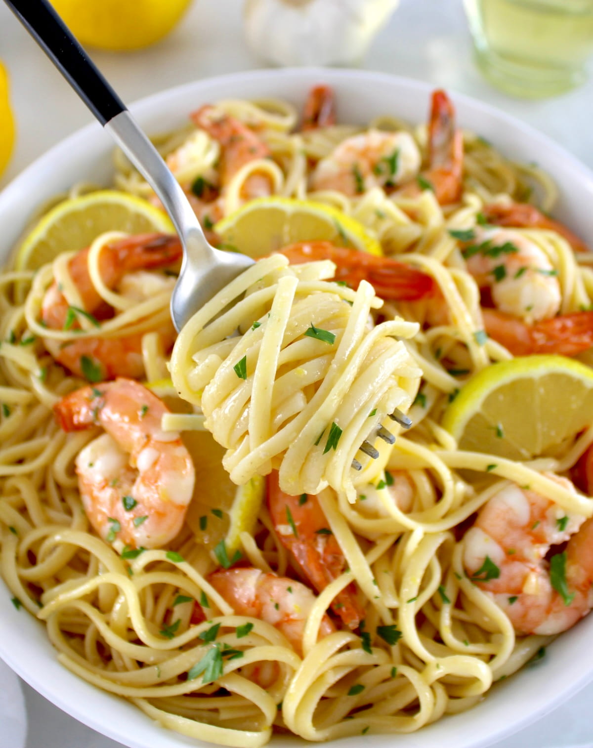 Shrimp Scampi with Linguine in white bowl with linguine twirled around fork