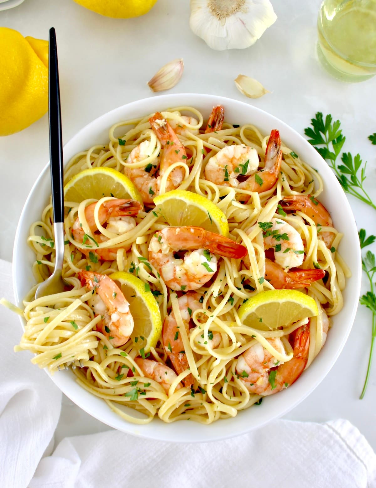 Shrimp Scampi with Linguine in white bowl with linguine twirled around fork