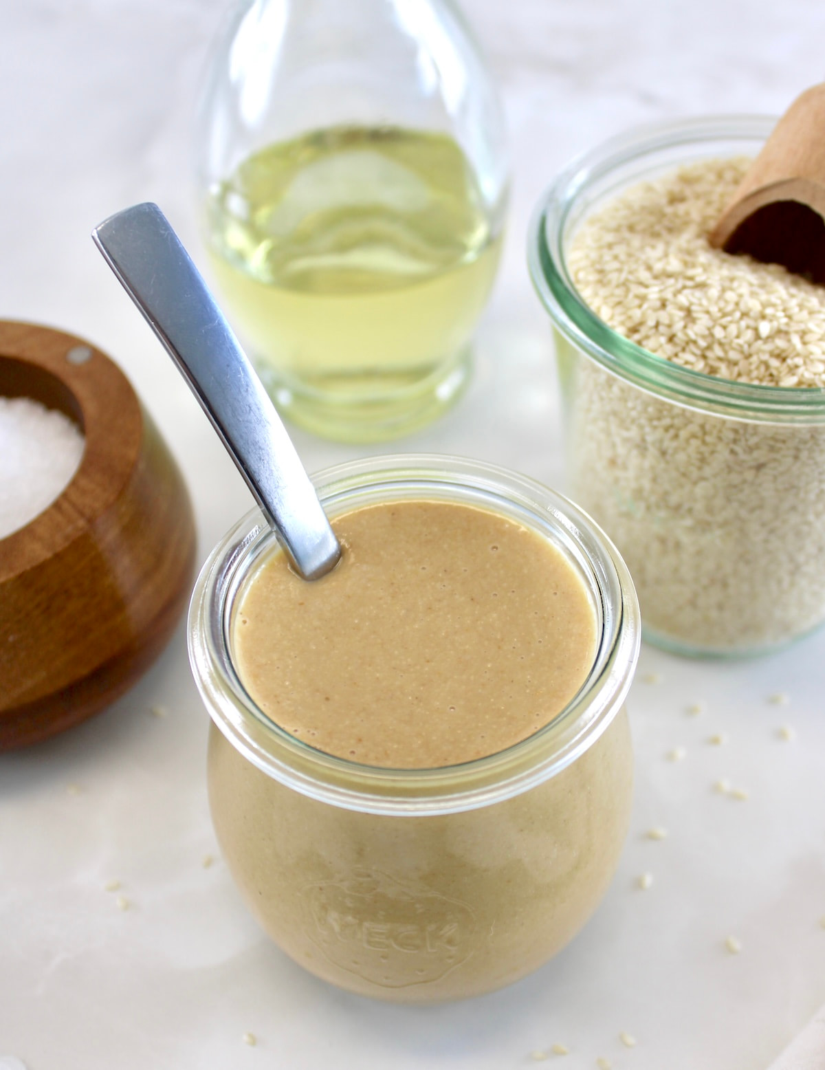 overhead view of Homemade Tahini in open glass jar with spoon