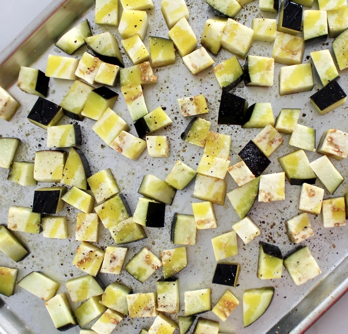 cubed raw eggplant on sheet pan with olive oil, salt and pepper
