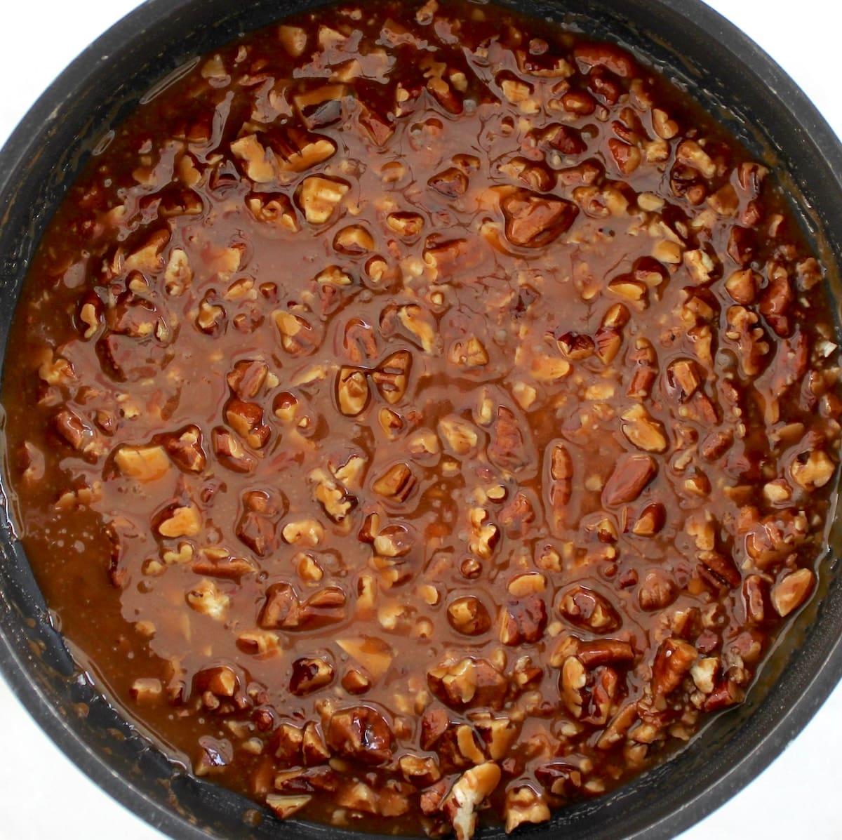 chopped pecans in caramel sauce in saucepan