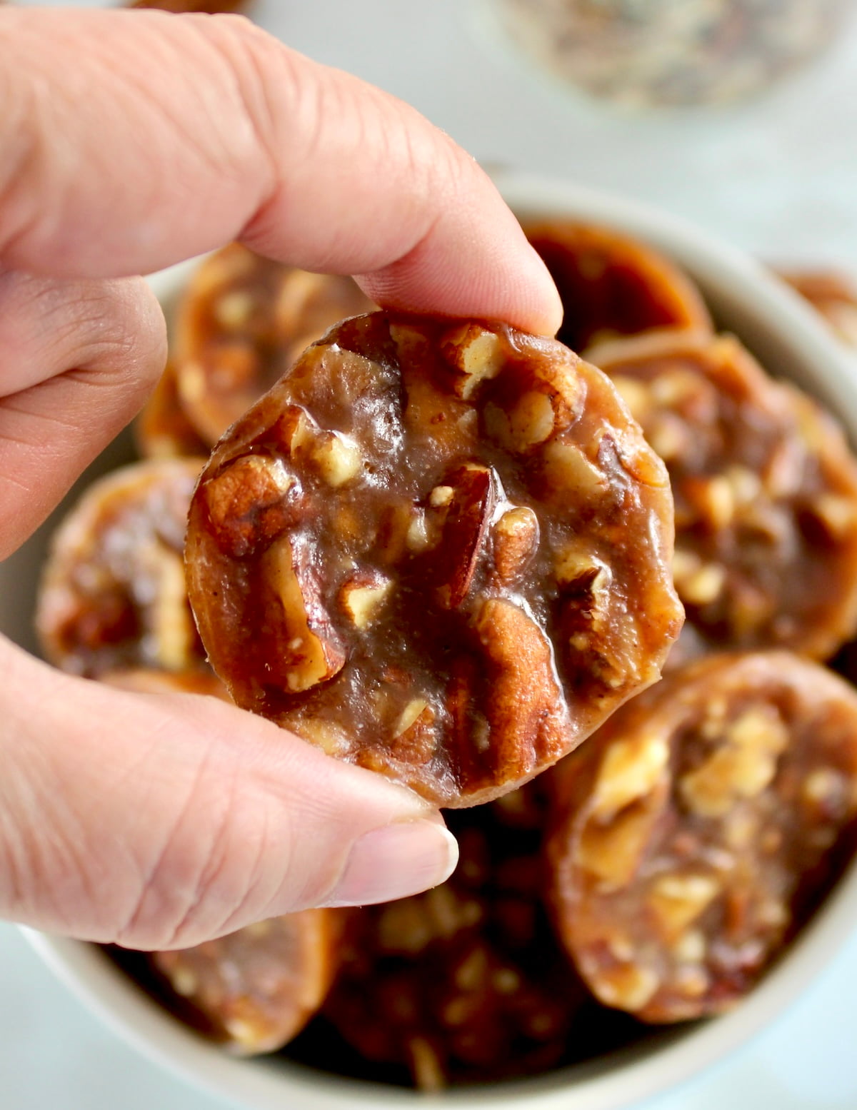 holding up a Pecan Caramel Cluster