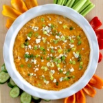 Cottage Cheese Buffalo Chicken Dip in white dish with fresh veggies around