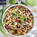 overhead view of Cowboy Coleslaw in white bowl with veggies in back