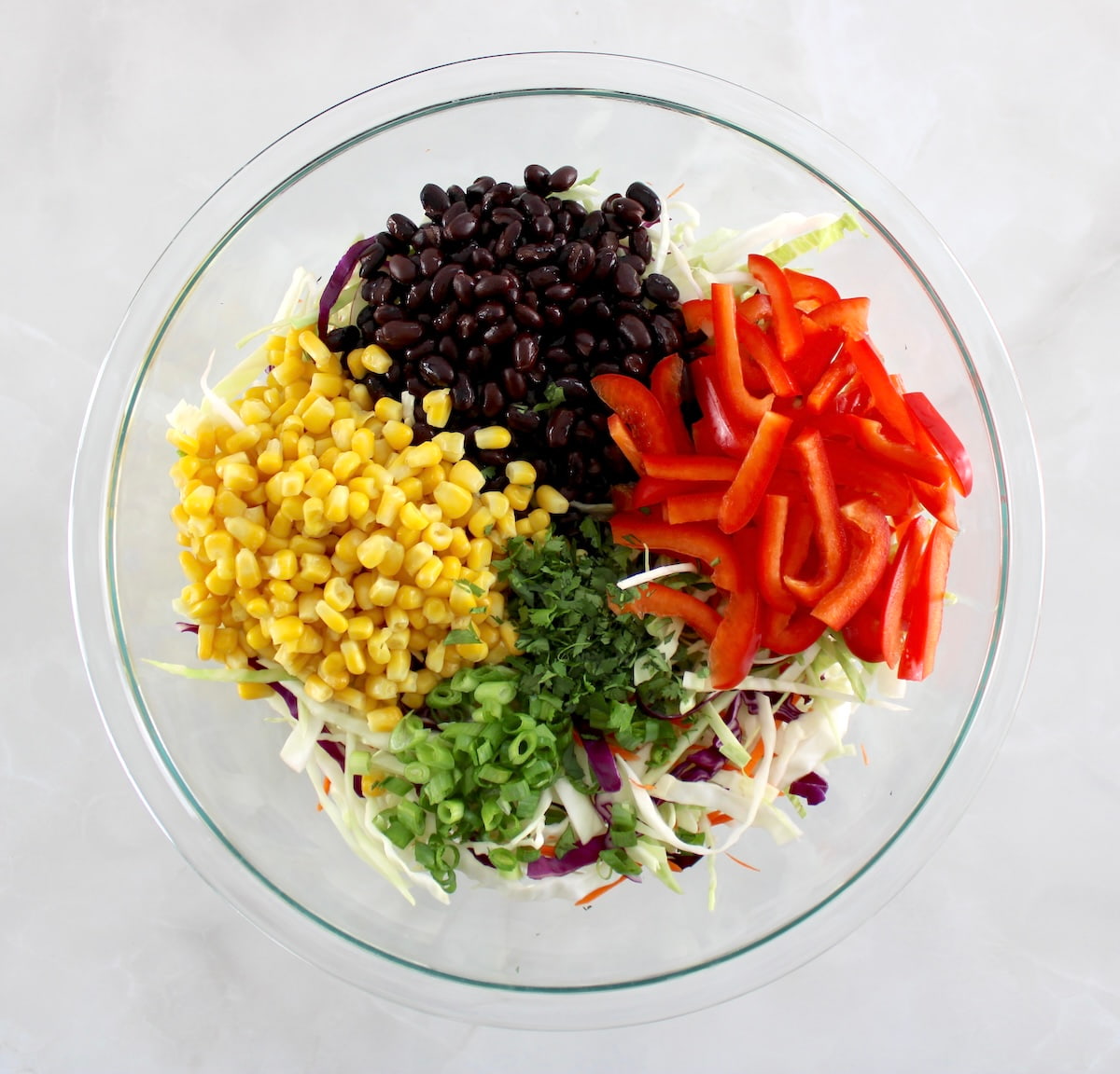 Cowboy Coleslaw ingredients in glass bowl in sections unmixed