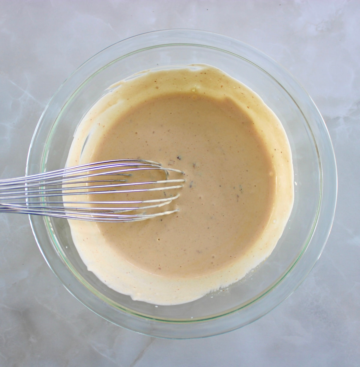 Cowboy Coleslaw dressing in glass bowl with whisk