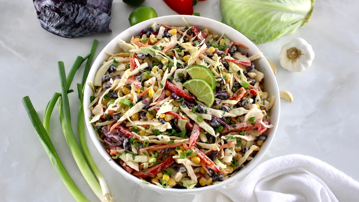 overhead view of Cowboy Coleslaw in white bowl with scallions on side