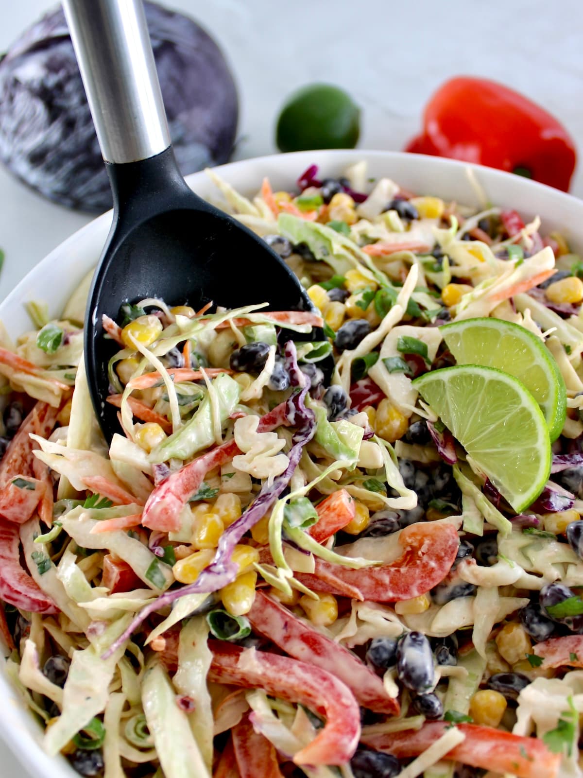 Cowboy Coleslaw in white bowl with black serving spoon