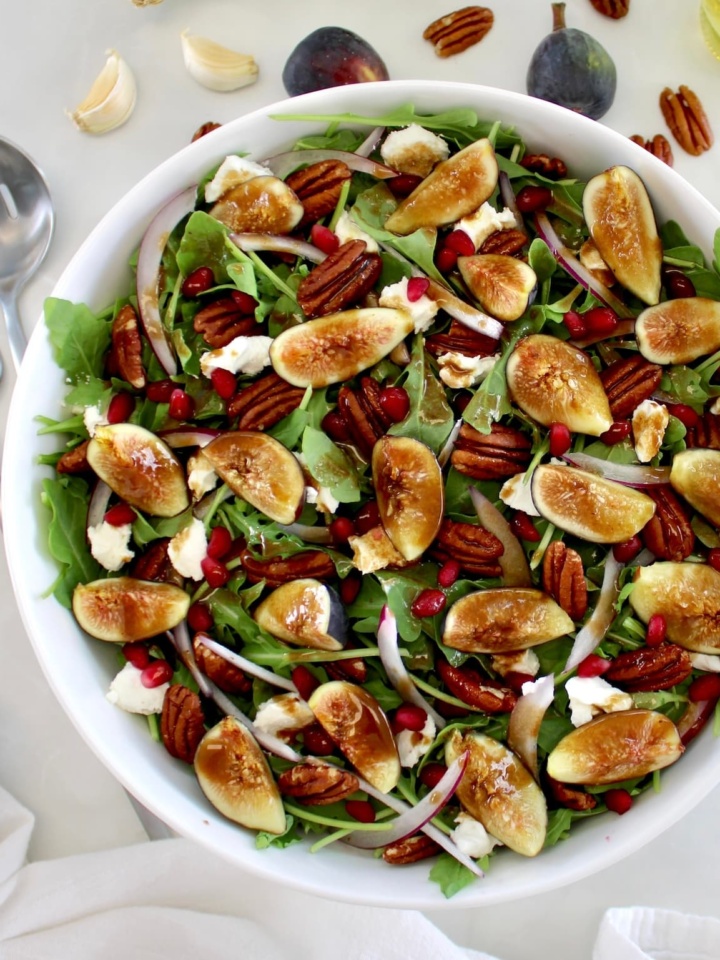 Fig and Arugula Salad in white bowl with balsamic dressing on top