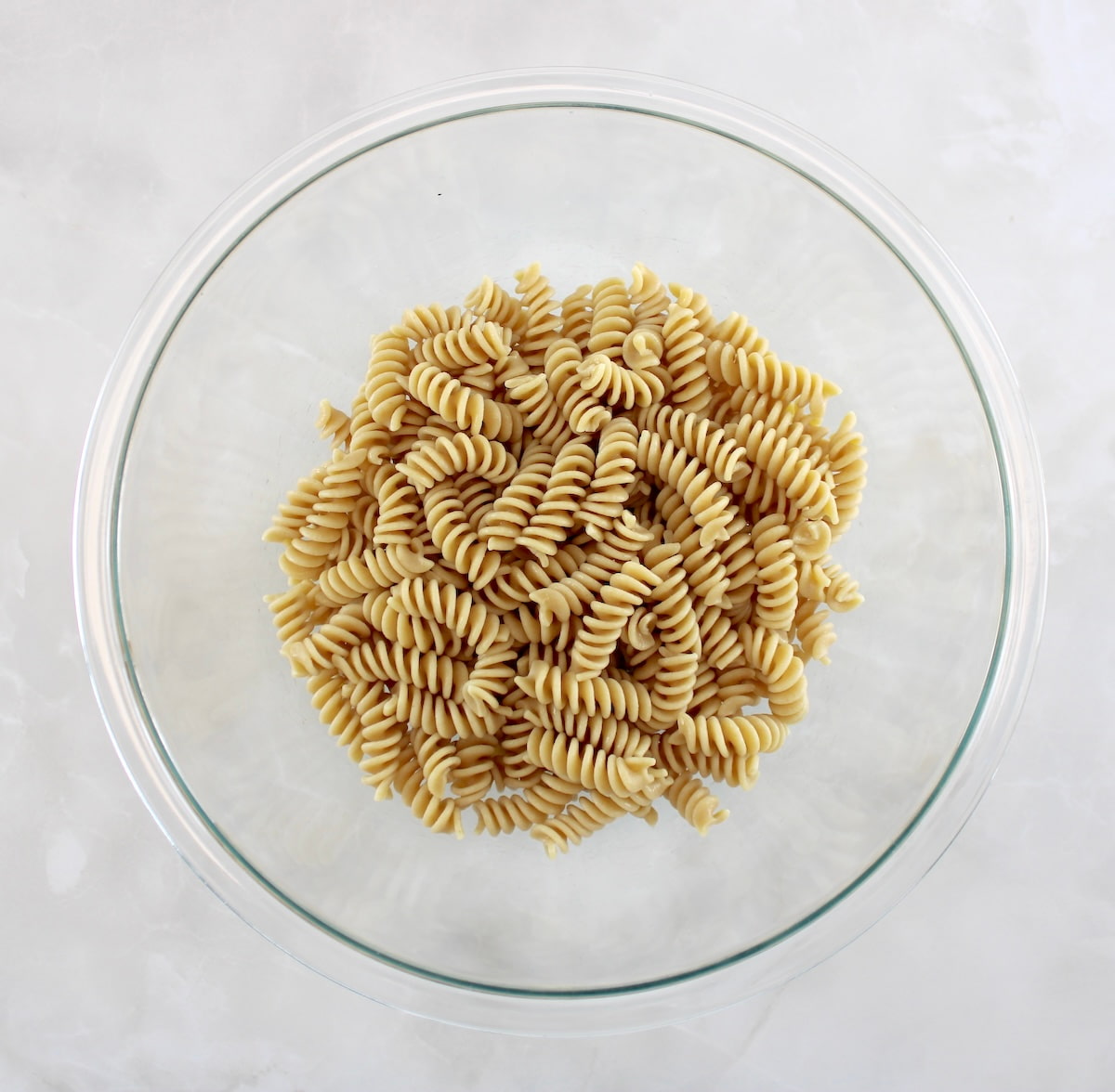 whole wheat rotelli pasta in glass bowl