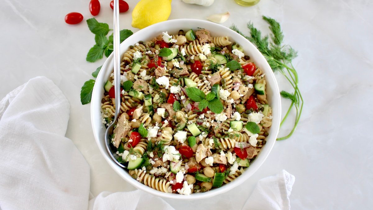overhead view of Chickpea Tuna Pasta Salad in white bowl with spoon on side