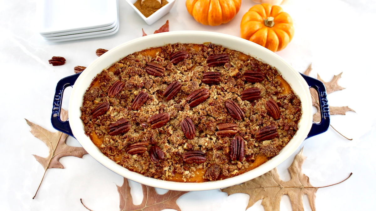 overhead view of Pumpkin Casserole with fall leaves and pumpkins in back